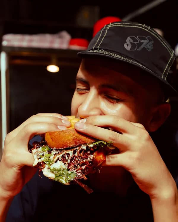 Cliente dándole una mordida al sándwich de brisket
